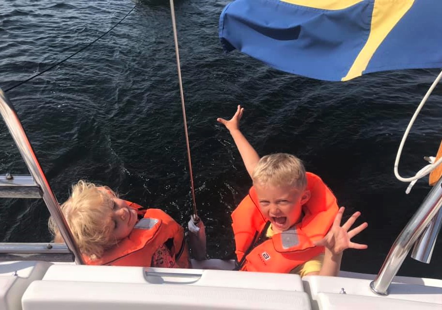 Barn med flytväst på segelbåt